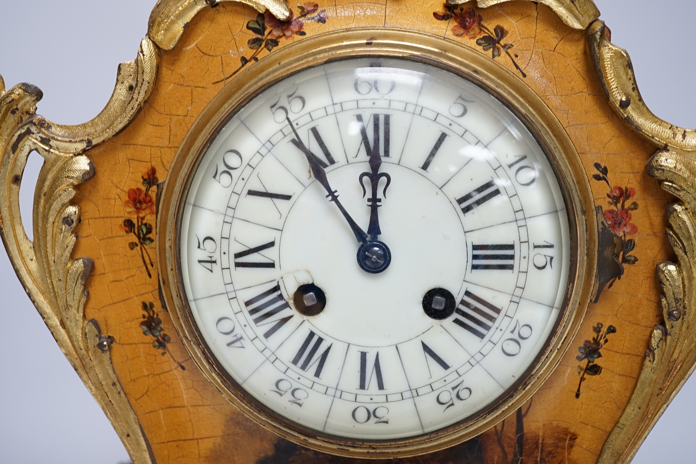 A late 19th century French Vernis Martin ormolu mounted clock with key and pendulum and a pair of brass candlesticks, tallest 44cm